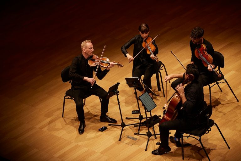 The Australian String Quartet performing live on stage with violins, viola, and cello.